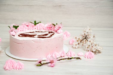 Açık arkaplanda pembe kremalı pasta ve boya makinesi.