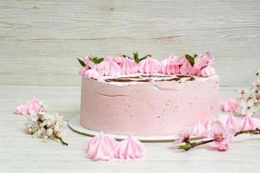 Açık arkaplanda pembe kremalı pasta ve boya makinesi.