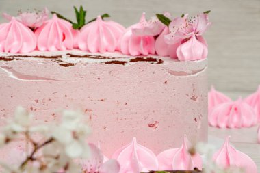 Açık arkaplanda pembe kremalı pasta ve boya makinesi.