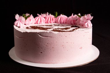 Siyah zemin üzerinde pembe lokum keki ve boyalı bir makine.