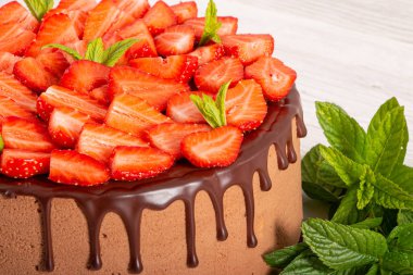 İçinde profiterol ve çilek olan kremalı pasta.