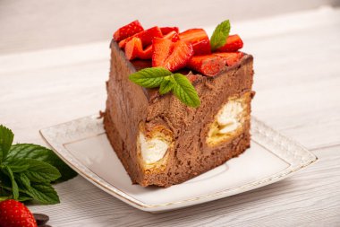 İçinde profiterol ve çilek olan kremalı pasta.