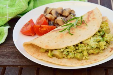 Tortilla çırpılmış yumurta avokado ile mantar ve domates ile servis