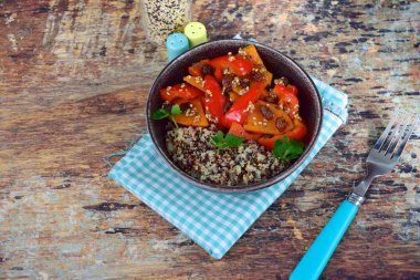 Tatlı patates, kuru üzüm, dolma biber, susam tohumu ve maydanozla pişirilmiş kırmızı ve beyaz kinoa. Sağlıklı vejetaryen yemekleri