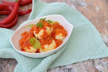 Telur Balado, haşlanmış yumurta, domates ve biber ezmesi ya da sambal ile servis edilir. Endonezya mutfağı