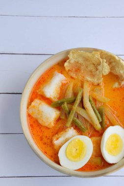 Lontong Sayur, Endonezya mutfağı. Hindistan cevizi sütü ve baharatlarla pişirilmiş pirinç keki veya sebzeli Lontong (chayote ve uzun fasulye). Haşlanmış yumurta ve krakerle servis edilir.