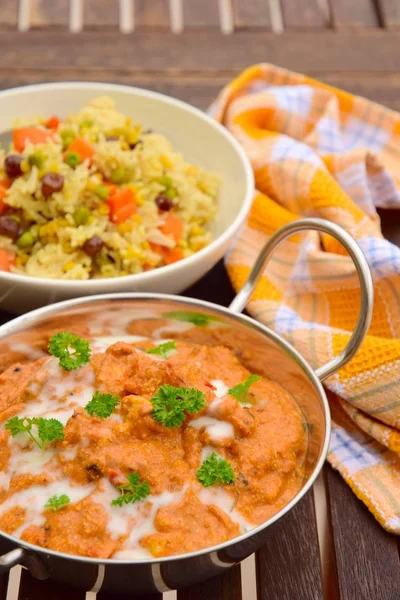 Butter chicken or murgh makhani. Indian cuisine, chicken in a spiced curry sauce served with biryani