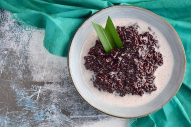 Bubur Ketan Hitam, Endonezya tatlısı. Hindistan cevizi sütü, palmiye şekeri ve pandan yaprağı ile siyah glutinous pirinç lapası..