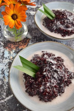 Bubur Ketan Hitam, Endonezya tatlısı. Hindistan cevizi sütü, palmiye şekeri ve pandan yaprağı ile siyah glutinous pirinç lapası..