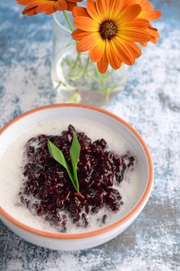Bubur Ketan Hitam, Endonezya tatlısı. Hindistan cevizi sütü, palmiye şekeri ve pandan yaprağı ile siyah glutinous pirinç lapası..