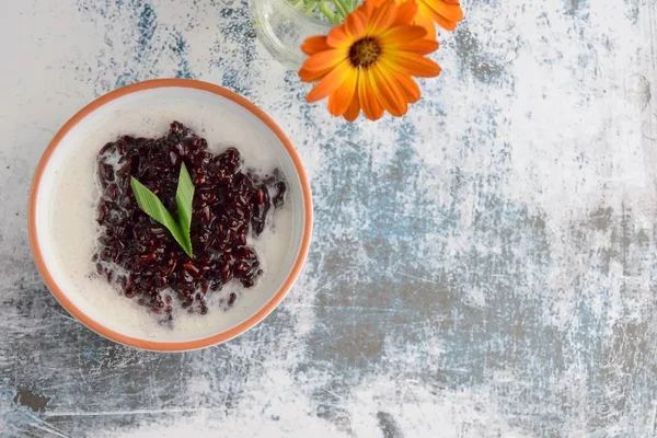 Bubur Ketan Hitam, Endonezya tatlısı. Hindistan cevizi sütü, palmiye şekeri ve pandan yaprağı ile siyah glutinous pirinç lapası..