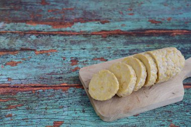 Tahtanın kenarındaki ağaç kesme tahtasının yanında bir de bıçak dilimleri.