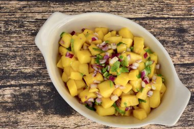 Ahşap arka planda taze ev yapımı mango salsası.