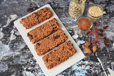 Kakao tozu, badem ezmesi, goji üzümü, kuru üzüm, akçaağaç şurubu ve hindistan cevizi yağı içeren sağlıklı enerji barları.