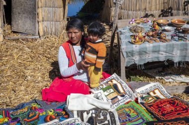 Puno, Peru - 10 / 06 / 2019: El yapımı dokumasını gösteren uro kadın