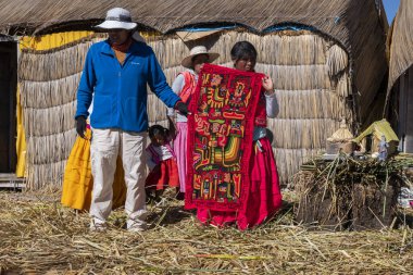 Puno, Peru - 10 / 06 / 2019: El yapımı dokumasını gösteren Uro insanları