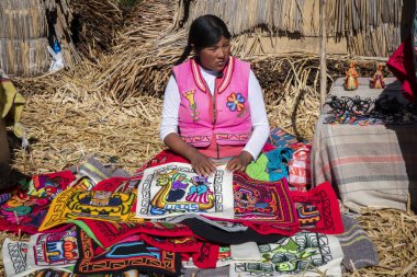 Puno, Peru - 10 / 06 / 2019: El yapımı dokumasını gösteren uro kadın
