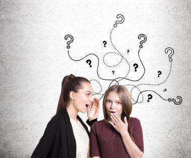 Beton duvarın yanında sohbet iki kız