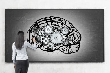 Woman working at brain sketch on blackboard