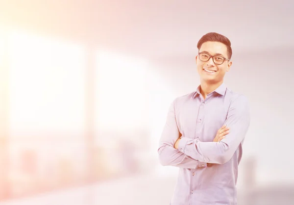 Sonriente hombre de negocios asiático en borrosa oficina soleada — Foto de Stock