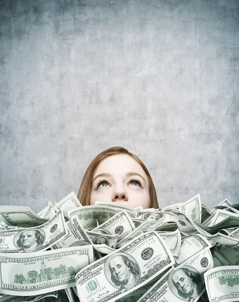 Meisje opgestapeld in cash in donkere grijze kamer — Stockfoto