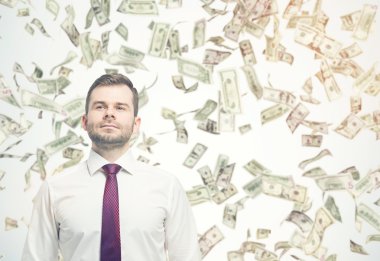 Güneşli günde dolar dolar yağmur altında emin işadamı