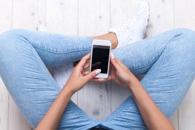 Woman in blue jeans with cellphone