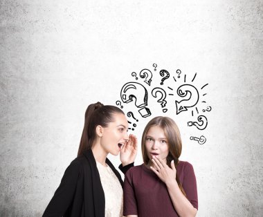 Women gossiping near concrete wall