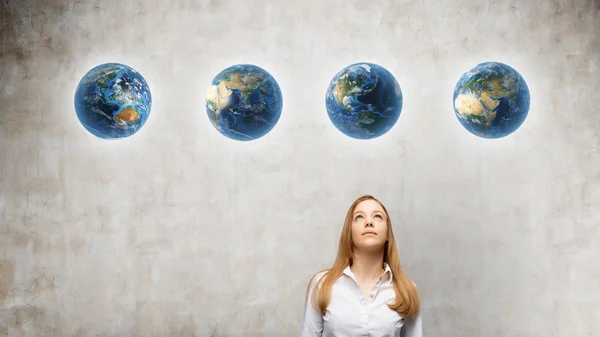 Girl looking at one of the globes — Stock Photo, Image