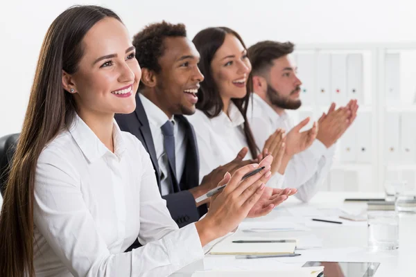 Group of colleagues applauding to some person off camera while sitting at the office. Concept of recognition and approval — Stock Photo, Image