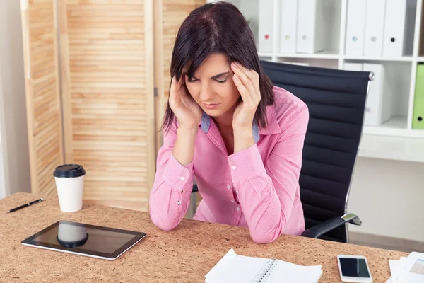 Woman with headahce in office — Stockfoto