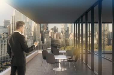 Cam duvarlı mavi ofiste işadamı