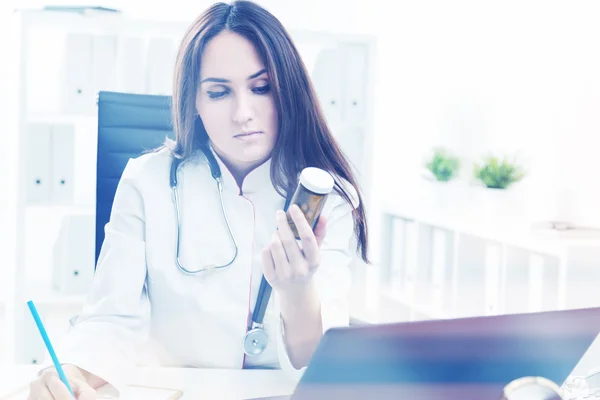 Médico en el trabajo y examinando pastillas — Foto de Stock