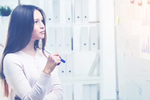 Pretty woman looking at office whiteboard — Stock Photo, Image