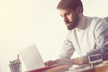 Ofiste çalışan sakallı adam. Yan görünüm