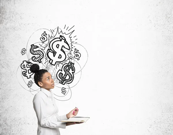 Menina africana com caderno e sinais de dólar brilhante — Fotografia de Stock