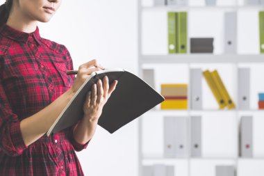 Kırmızı damalı gömlek ciddi kız notlar alarak