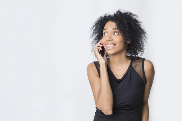 Sorrindo menina africana está falando em seu telefone celular — Fotografia de Stock