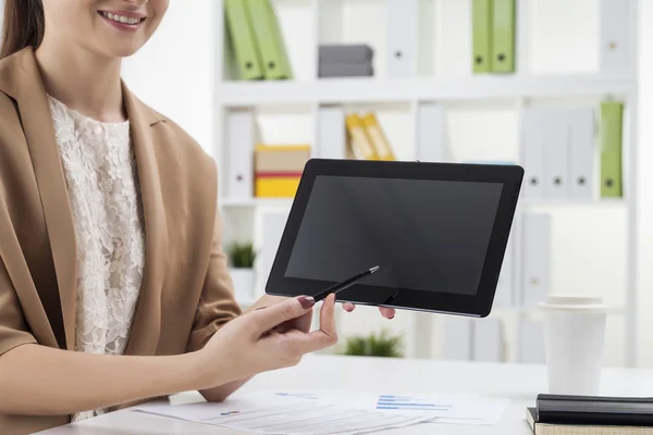 Menina sorridente apontando para a tela do computador tablet no escritório — Fotografia de Stock