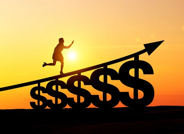Woman running up dollar signs stairs in desert — Stock Photo, Image
