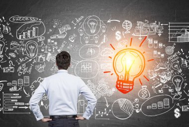 İş simgeleri ile kırmızı ampul bakarak Adam