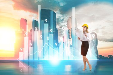 Woman in yellow hard hat and diagram against cityscape