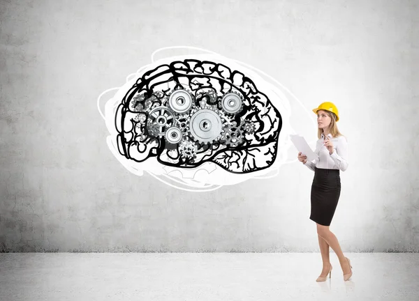 Woman in hard hat and brain with cogs