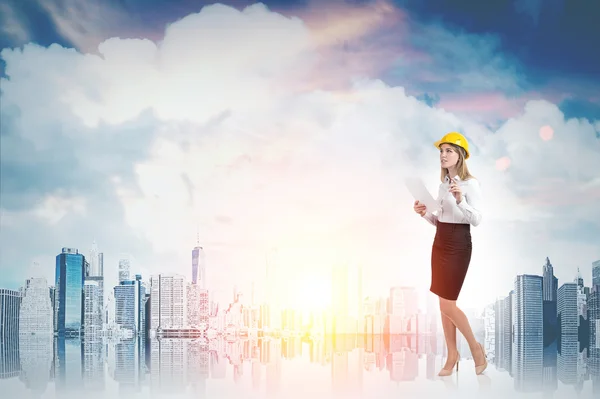 Woman in yellow hard hat and cityscape — 스톡 사진