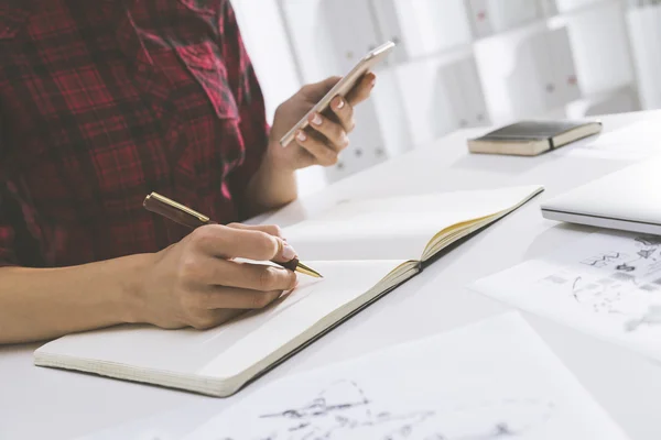 Vista inclinata della donna calligrafia con cellulare — Foto Stock