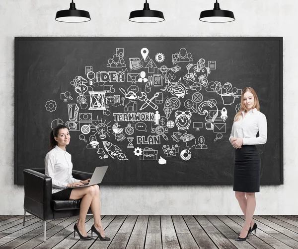 Meisje met laptop en blonde vrouw in de buurt van teamwork iconen — Stockfoto