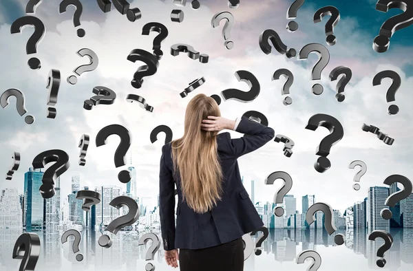 Woman scratching head and looking at question marks falling from — Stock Photo, Image