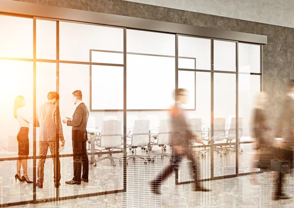 People in sunlit office with concrete walls — Stock Photo, Image