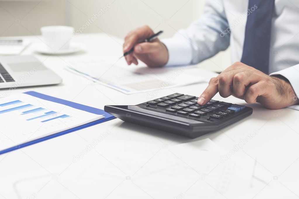 Man's hands using calculator