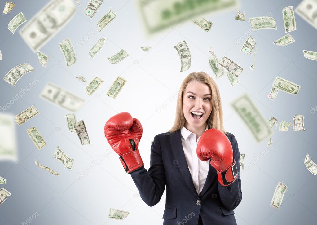 Girl in boxing gloves under dollar rain